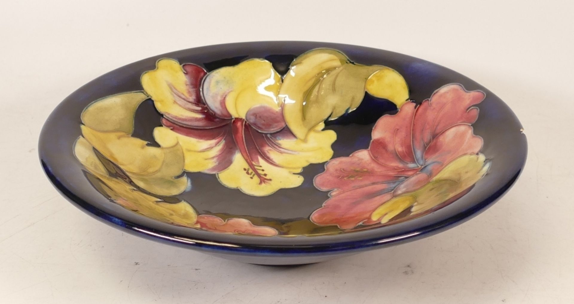 Moorcroft Hibiscus on Blue Ground Shallow Footed Bowl, chip to rim, diameter 24.5cm - Image 3 of 3