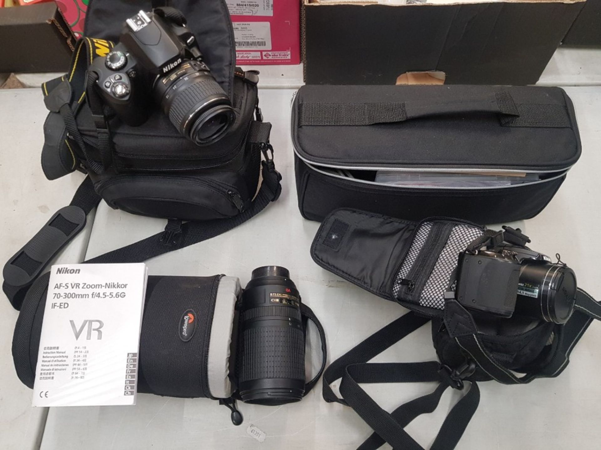 A collection of photographic equipment to include a Nikon D40x camera, Nikon AF-S VR 70 - 300mm