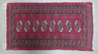 An Uzbek Bukhara Type Rug. Wear and fraying present. Length: 124cm Width: 63cm