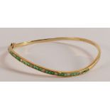 18ct gold diamond and emerald bangle, weight 8.4g.