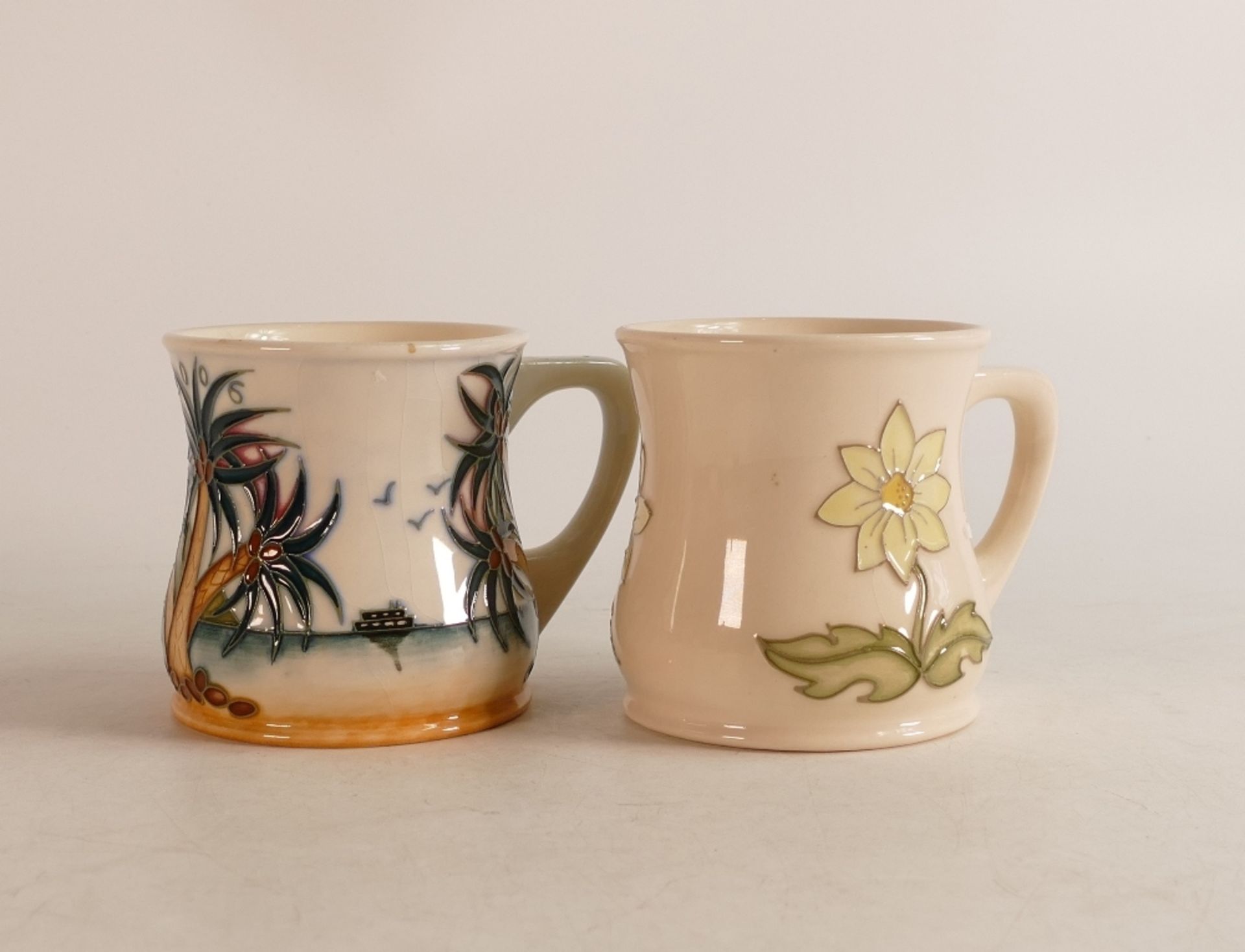 Two Moorcroft mugs to include Caribbean (crazed) and wild daisy (2)