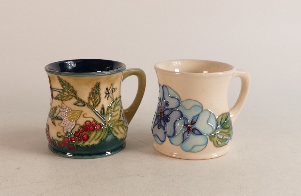 Two Moorcroft Mugs to include strawberries and wild berries together with blue pansies (crazed) (2)