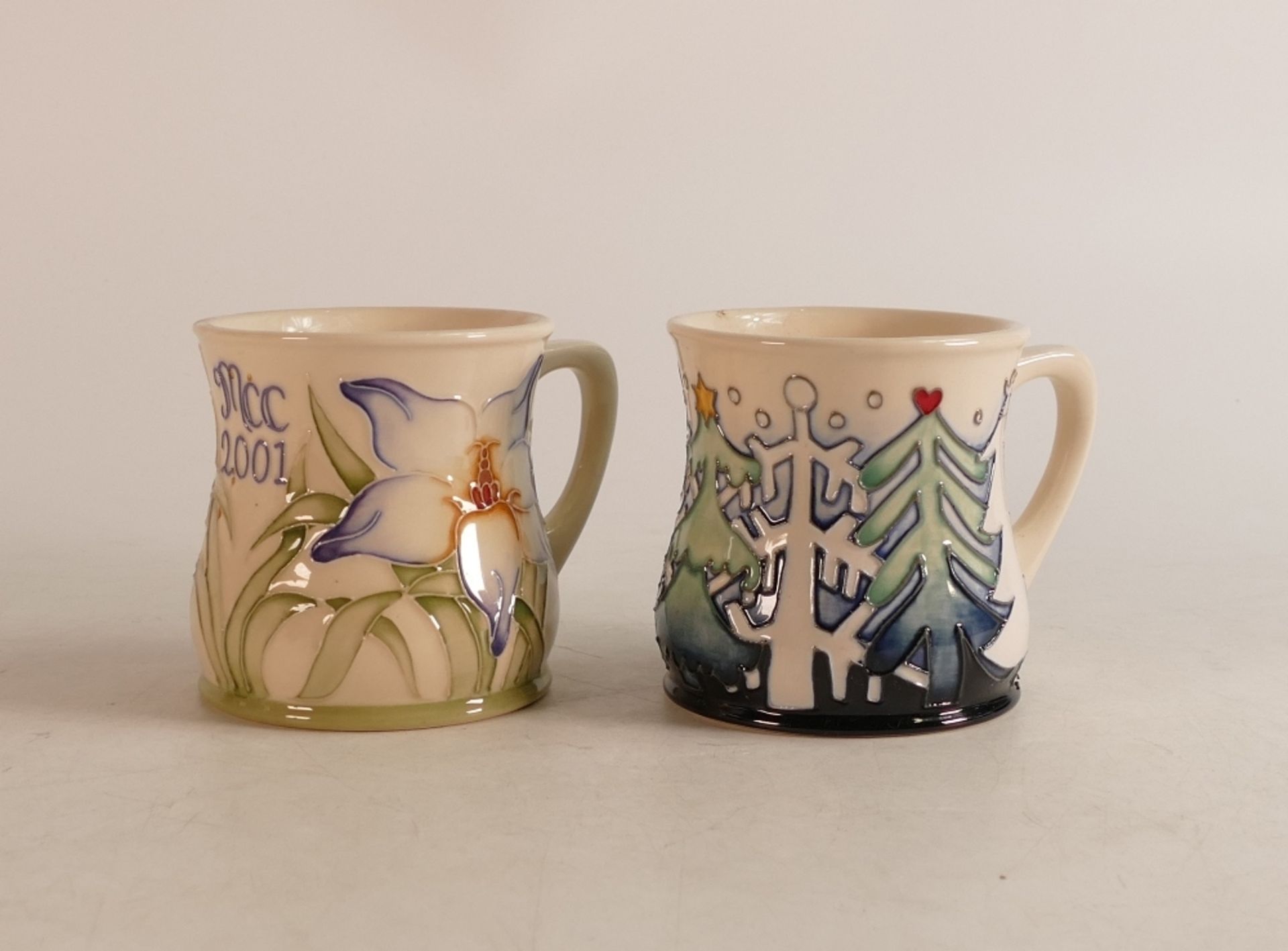 Two Moorcroft mugs to include MCC 2001 and Christmas woods (2)