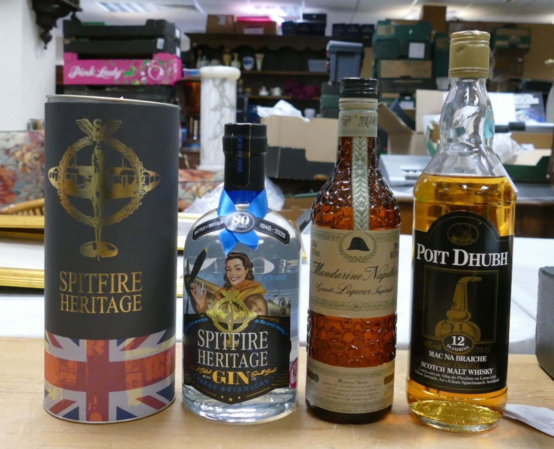 Bottle of Spitfire heritage gin in tin together with Poit Dhubh malt whiskey and Mandarine