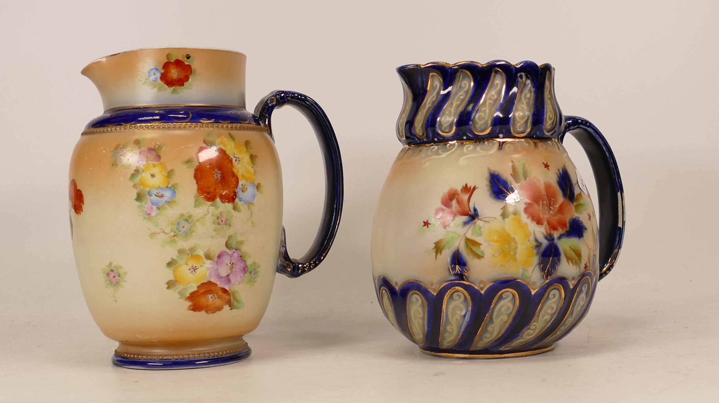 Carlton Ware Camellia patterned jug together with a Polyanthus patterned jug. Height 16cm (2)