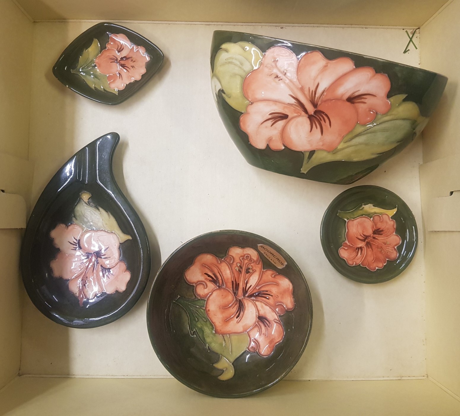 A collection of Moorcroft Hibiscus on green ground items to include small footed bowl, window sil