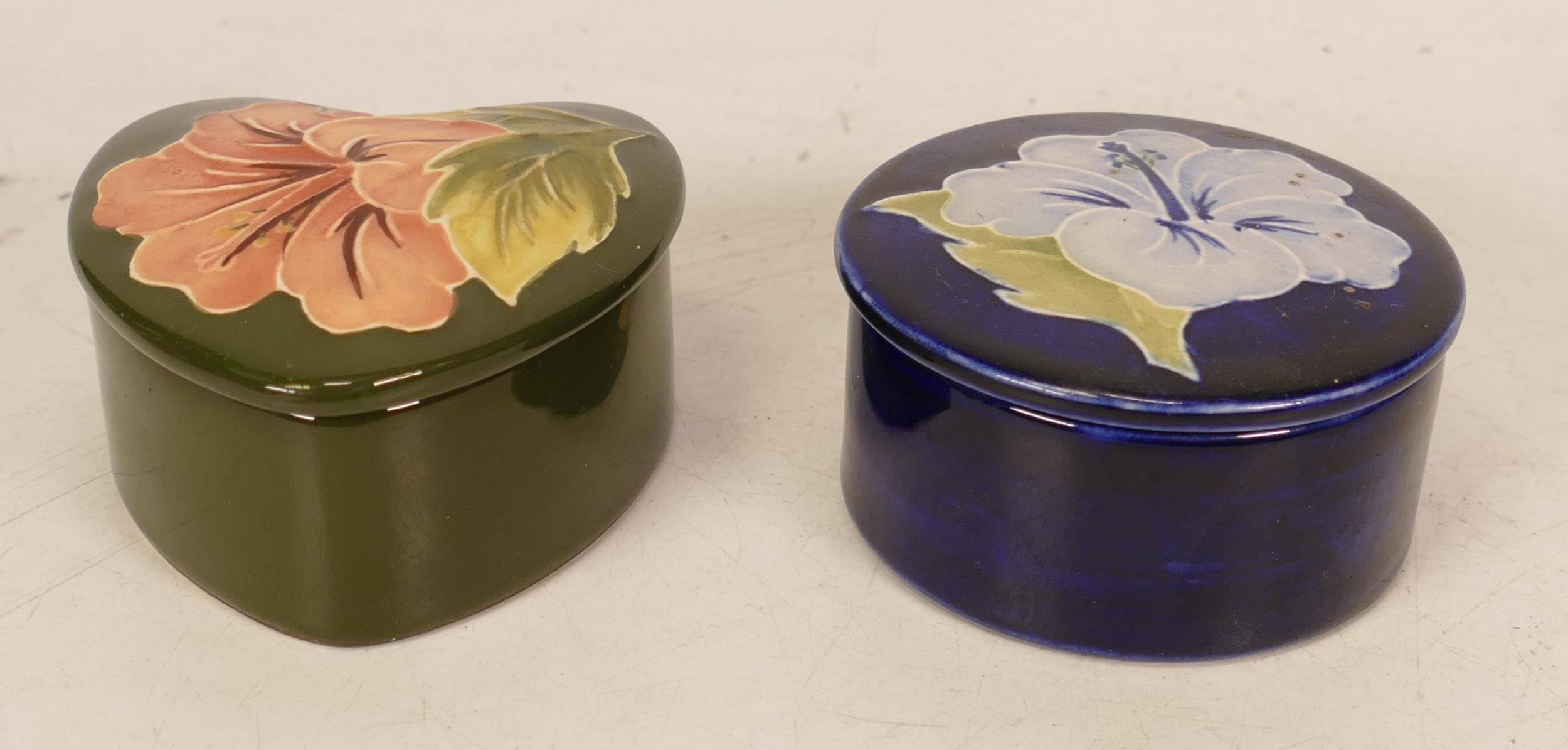 Moorcroft Hibiscus round lidded trinket box on blue ground together with Hibiscus heart shaped