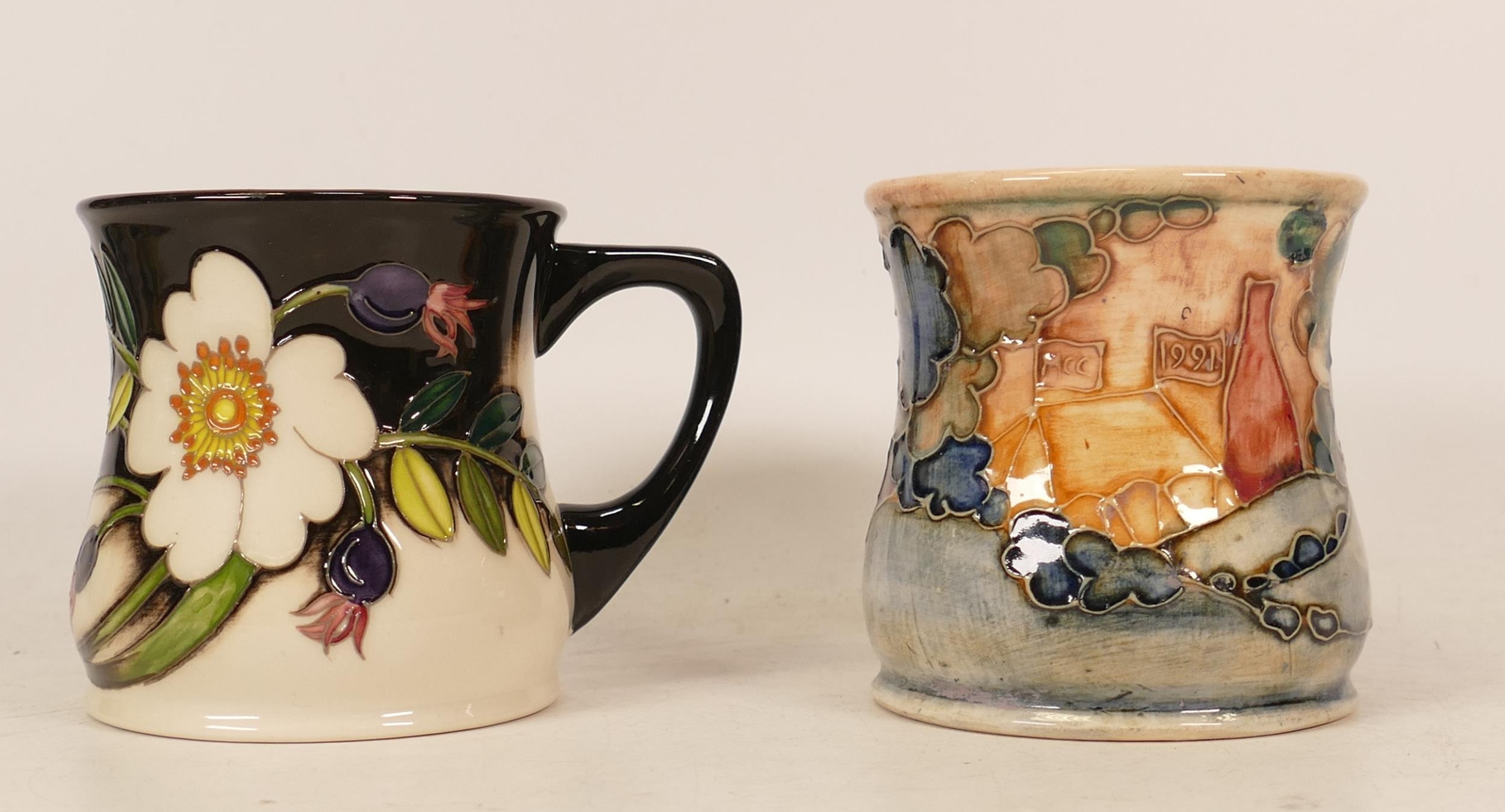 Moorcroft mug of the year 1991 and Moorcroft mug decorated with white flowers and berries, boxed (2)