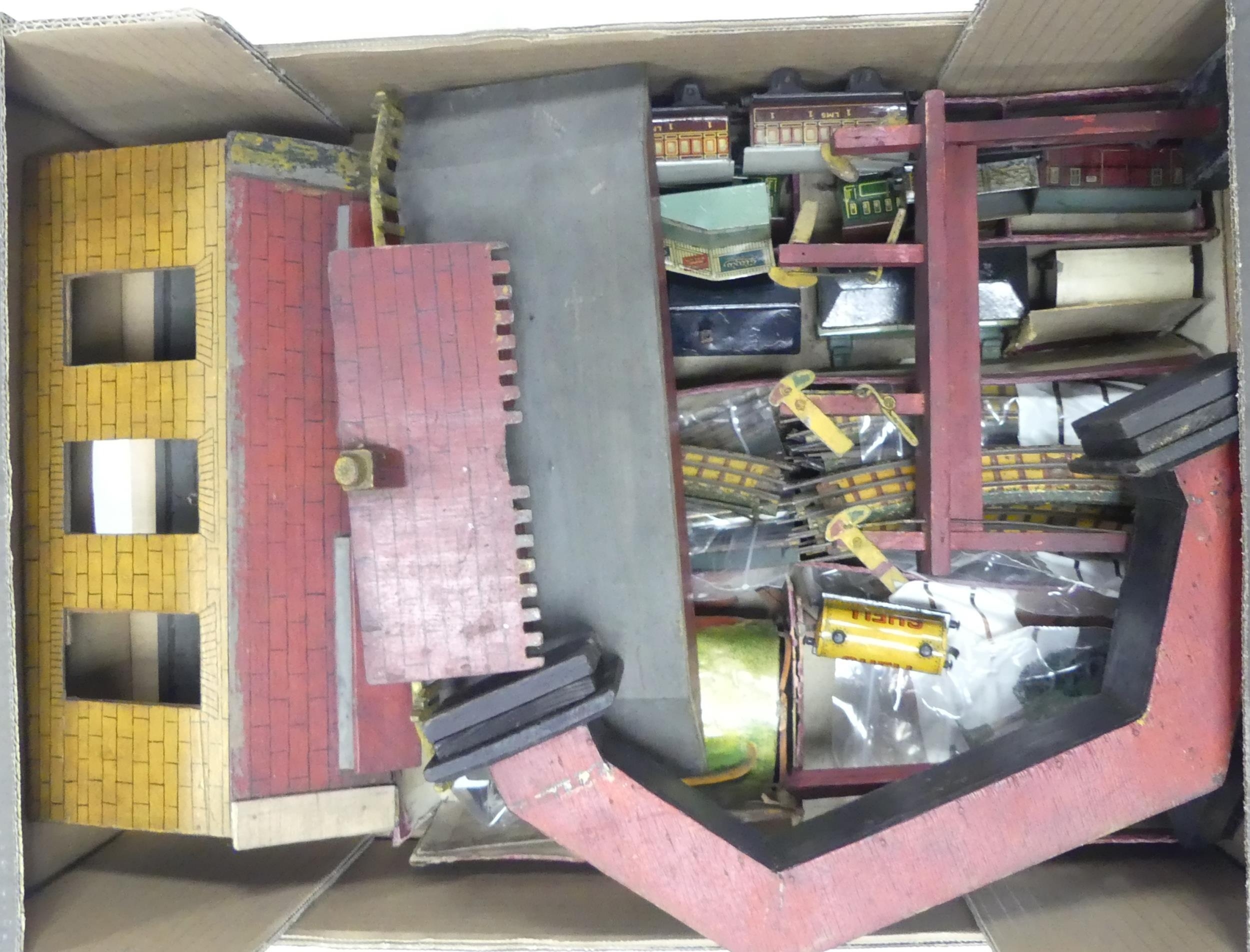 A collection of vintage tin train carriages and accessories to include Shell tank car, platform,