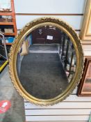 A modern gilt oval wall mirror having bevelled glass