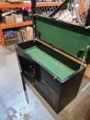 An old black lacquered wooden chest having rising lid, the cupboard doors containing 8 internal draw