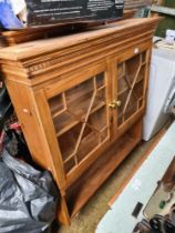 A pair of modern pine hanging wall units having glazed doors