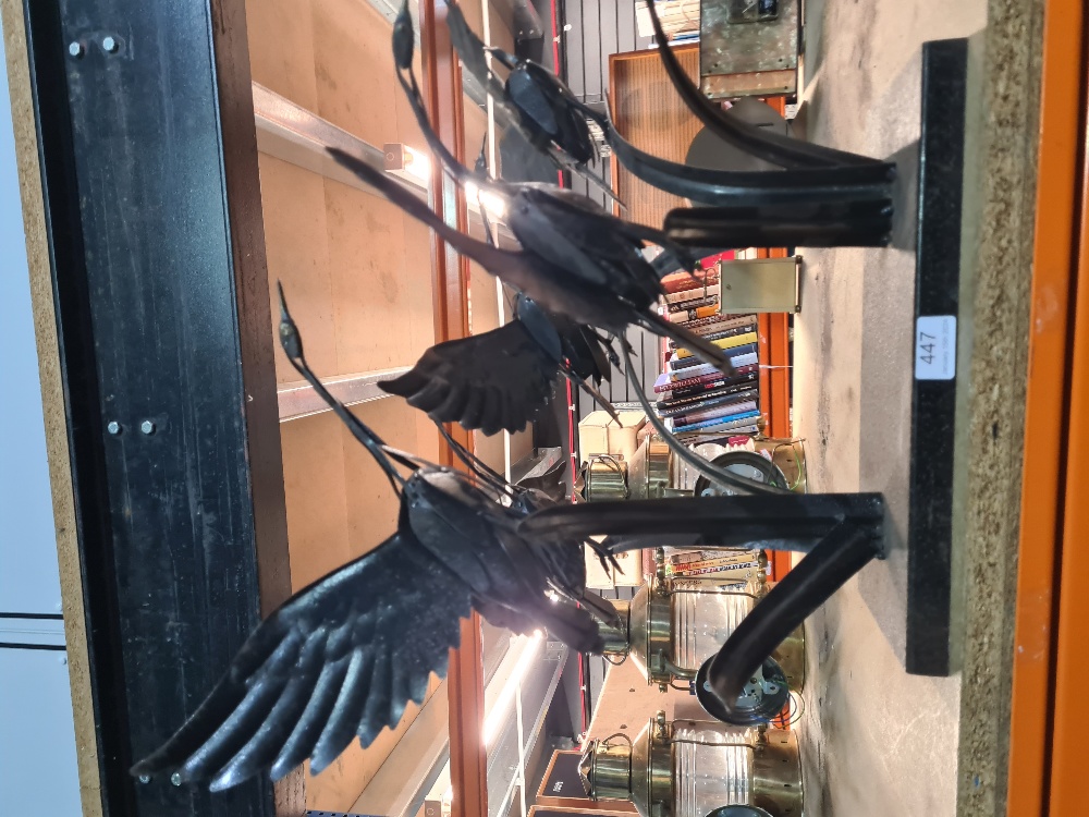 A metal sculpture of birds taking flight