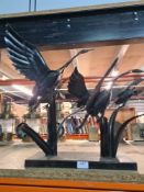 A metal sculpture of birds taking flight
