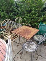 An iron scroll work garden bench, 2 similar chairs and a square table