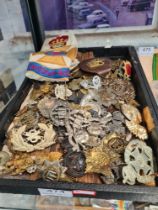 A tray of military cap badges and similar