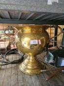 An old brass two handled pot on circular pedestal