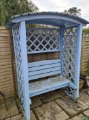 A Wooden garden love seat, having canopy top with lattice sides