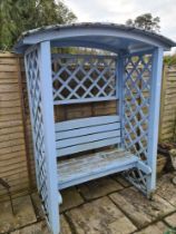 A Wooden garden love seat, having canopy top with lattice sides