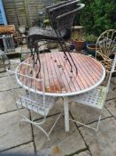 A circular garden table with wooden slatted top and 4 various chairs