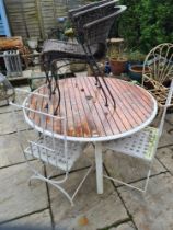 A circular garden table with wooden slatted top and 4 various chairs