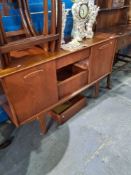 A 1970s Teak sideboard having 3 central drawers with 2 sliding doors, 127.5cm