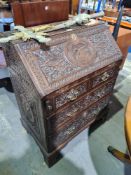 An antique oak Bureau probably early 19th Century, having all over carved decoration, 76cm