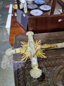 A large metal cross with some gilt decoration on associated wooden tripod stand, the cross 85.5cm