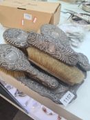 A large set of silver dressing table items. Embossed scroll design in relief comprising of four brus