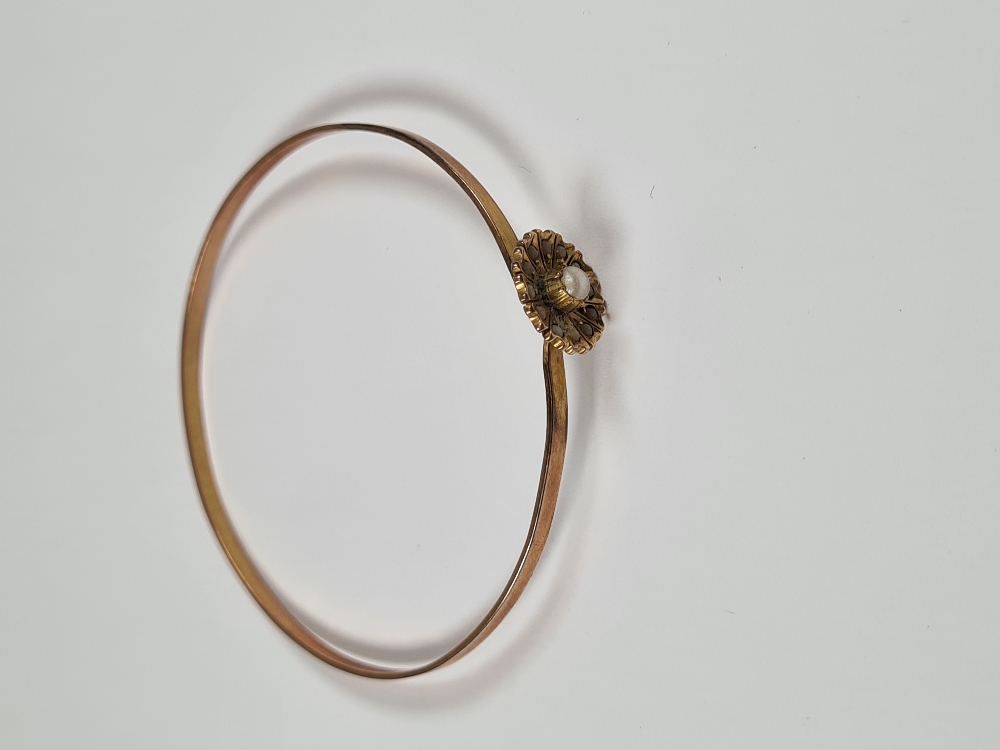 Unmarked yellow gold bangle with hook clasp below flowerhead, inset with seed pearls, 6cm diameter, - Image 13 of 17