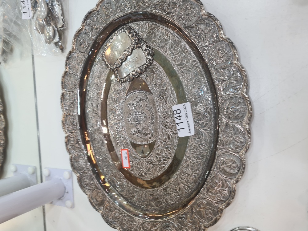 A white metal decorative tray having floral bordered pattern central motif enscribed 'Malaysia' and