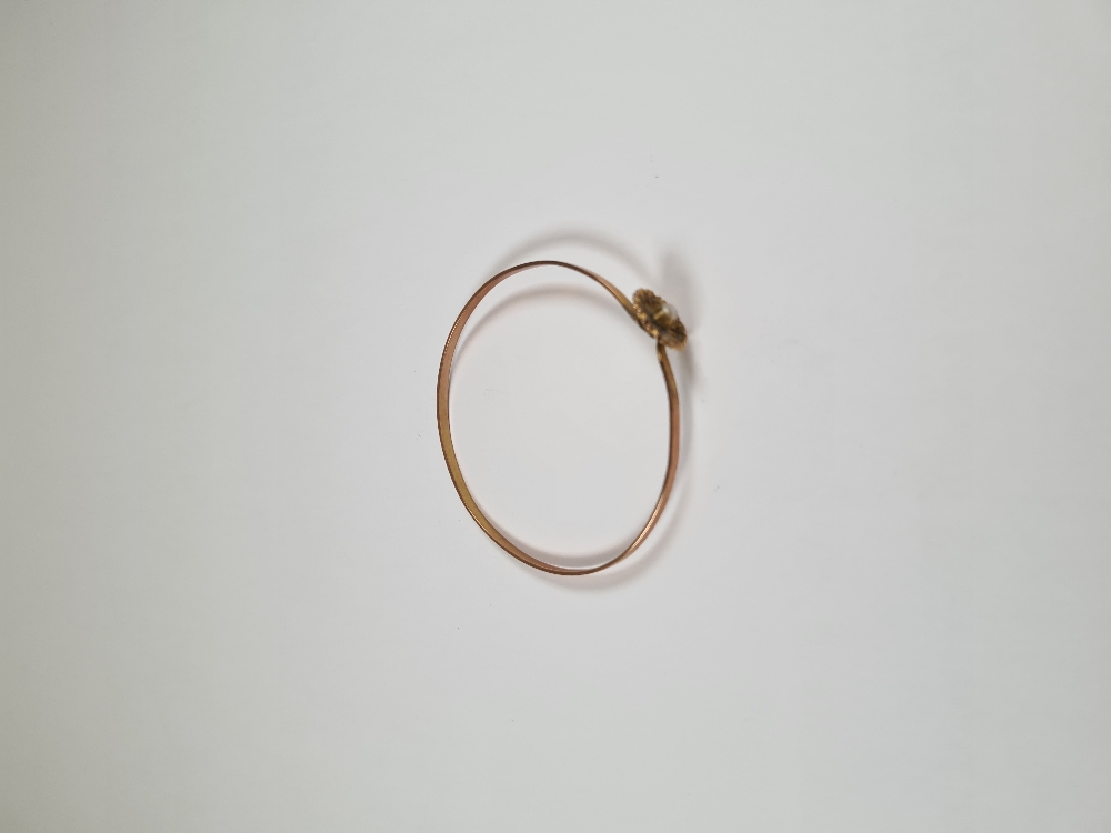 Unmarked yellow gold bangle with hook clasp below flowerhead, inset with seed pearls, 6cm diameter, - Image 6 of 17