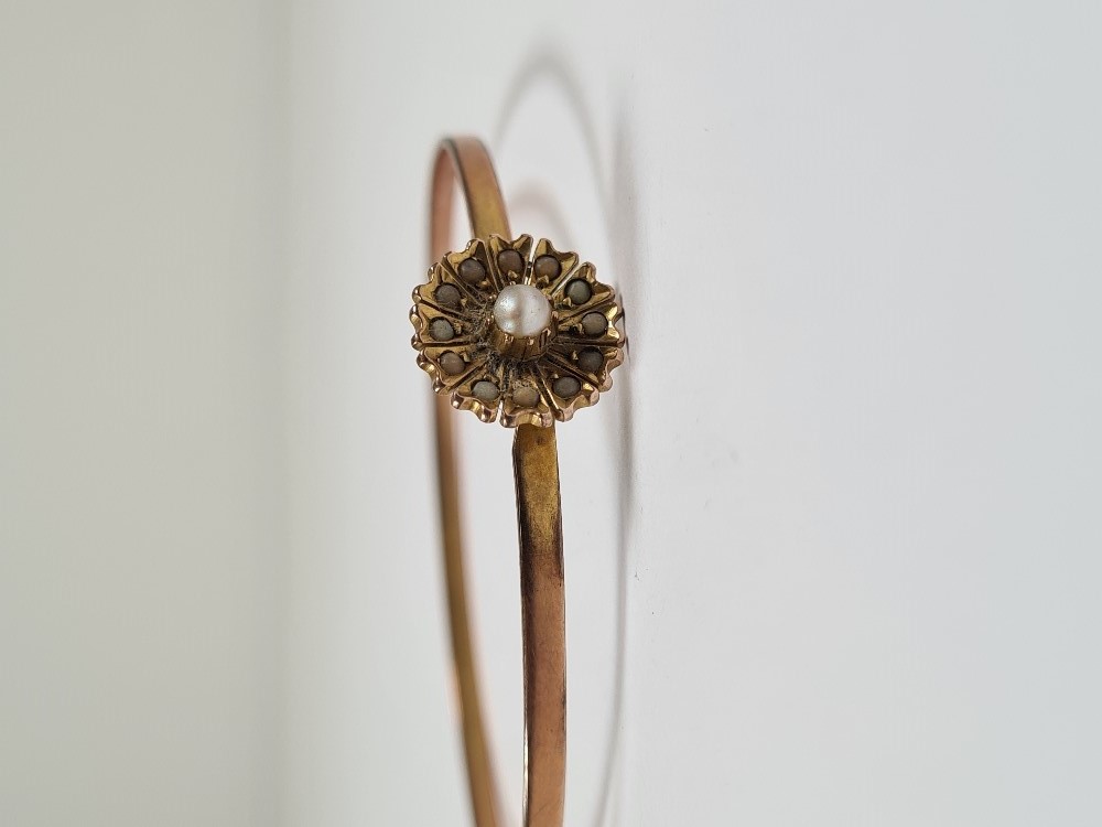 Unmarked yellow gold bangle with hook clasp below flowerhead, inset with seed pearls, 6cm diameter, - Image 16 of 17