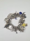 Heavy silver charm bracelet by Jacob Bender, hung with a large quantity of charms, travel tokens etc
