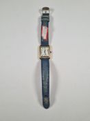 Cartier; A 18K gold plated Cartier wristwatch white dial and Roman numerals, on blue leather strap