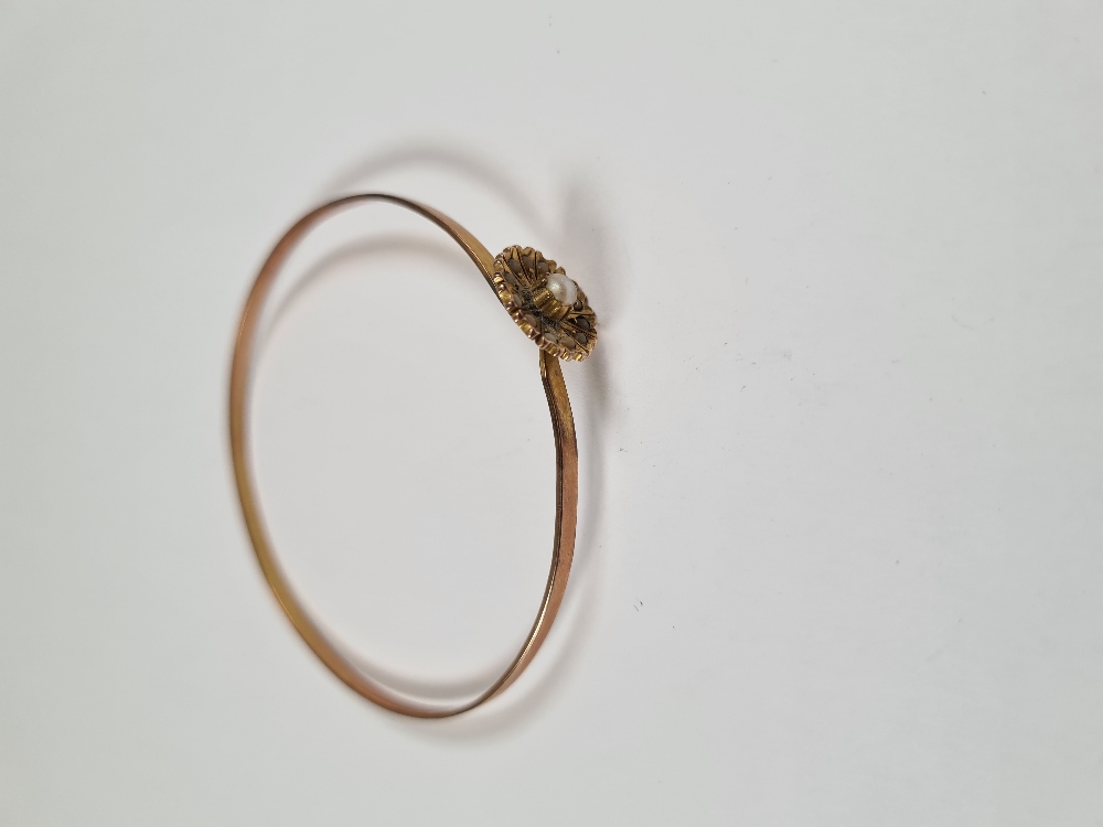 Unmarked yellow gold bangle with hook clasp below flowerhead, inset with seed pearls, 6cm diameter, - Image 2 of 17