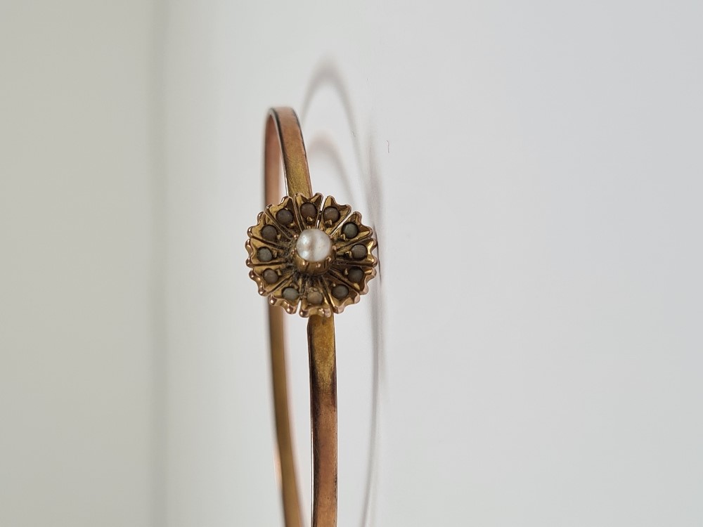 Unmarked yellow gold bangle with hook clasp below flowerhead, inset with seed pearls, 6cm diameter, - Image 12 of 17