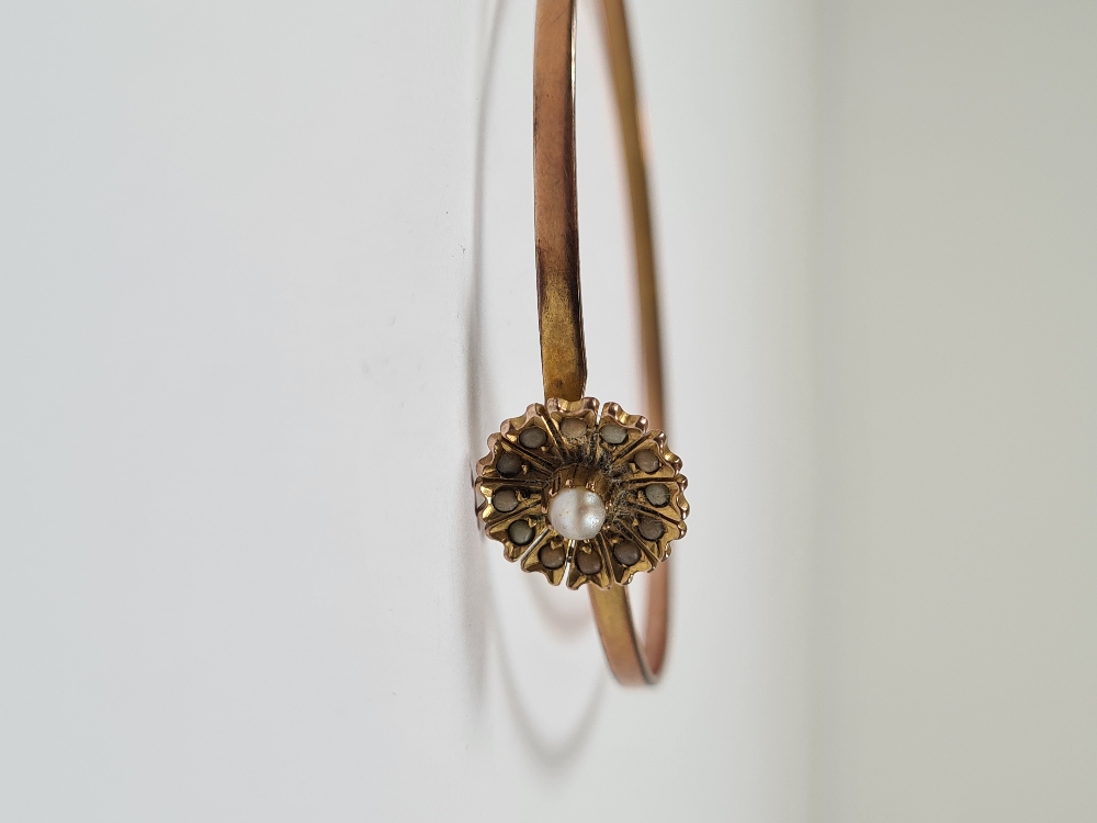 Unmarked yellow gold bangle with hook clasp below flowerhead, inset with seed pearls, 6cm diameter, - Image 5 of 17