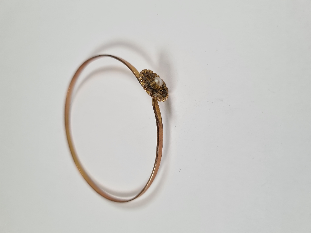 Unmarked yellow gold bangle with hook clasp below flowerhead, inset with seed pearls, 6cm diameter, - Image 7 of 17