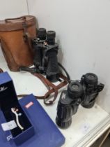 A pair of vintage binoculars possibly military in leather case and one other more modern pair