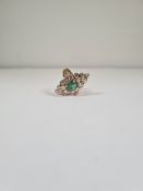 18K yellow gold dress ring with large stepped and domed marquis panel with central oval cut emerald