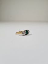 18ct yellow gold emerald and diamond trilogy ring, with central oval mixed cut emerald with a brilli