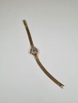 14K yellow gold ladies cocktail watch with oval dial and baton markers by Dugena, on 14K yellow gold