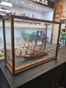 An antique model of early 19th Century Royal Navy masted Schooner in glazed case measuring 55.5cm x