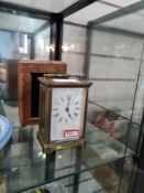 A brass carriage clock with leather case