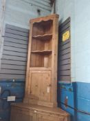 An antique pine standing corner cupboard having open shelves with cupboard below