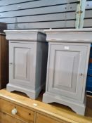 A pair of shabby chic style bedside cupboards each having one door