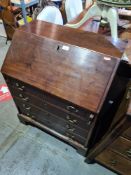 A small antique mahogany bureau having 4 long drawers on bracket feet