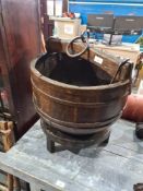 An old well bucket having iron band, possibly Asian on later stand, 47cm