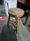 An old milking stool on turned legs, height 51cm